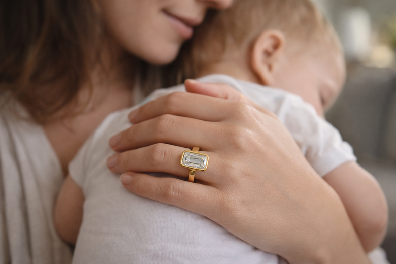 Mechanical Engineering Diagram showing force distribution on prong setting (concentrated at 4 points with stress indicators) versus bezel setting (radial distribution across 360-degree rim) with Newton force measurements - Transforms technical concept into instantly graspable visual