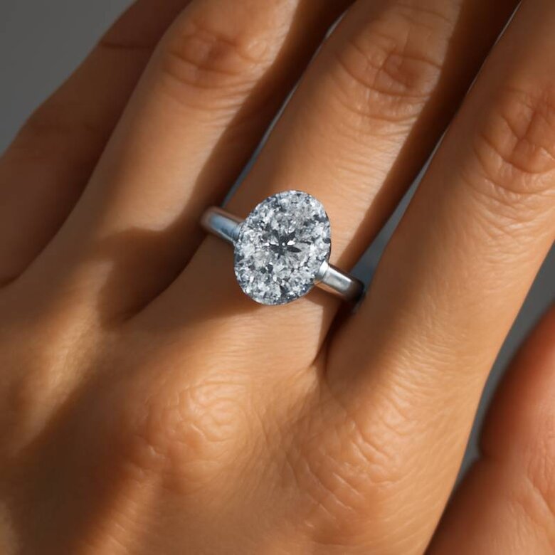 Image: Elegant Three-Stone Lab-Grown Diamond Ring on Hand - Showcasing proportional harmony between center and side stones with natural lighting emphasizing brilliant faceting and fire across oval center with tapered baguette sides