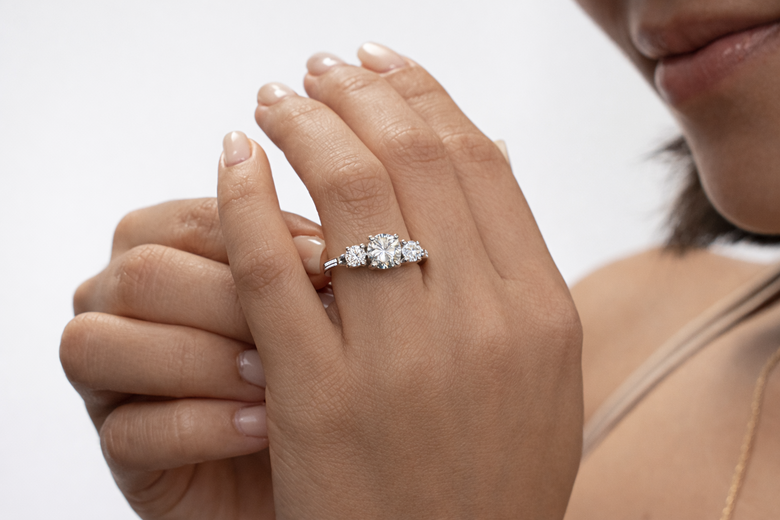 Three-Stone Ring Anatomy Diagram - Visualize the proportional relationship between center and side stones with labeled carat weight percentages and symbolic meaning for each position